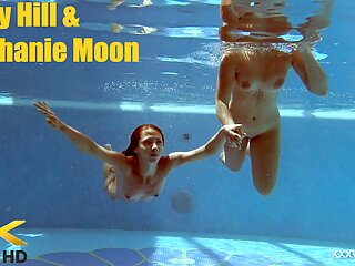 In the indoor pool, two stunning girls swim